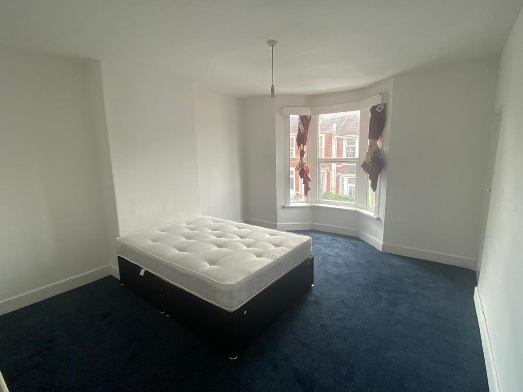 A bright double bedroom featuring a large bay w...