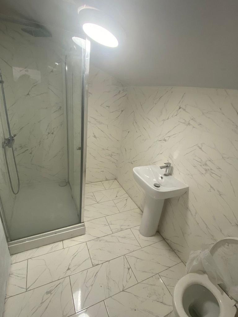 Bright and modern bathroom featuring white marb...