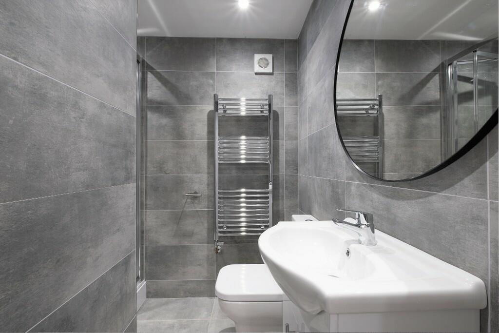Modern bathroom featuring sleek grey tiles, a s...