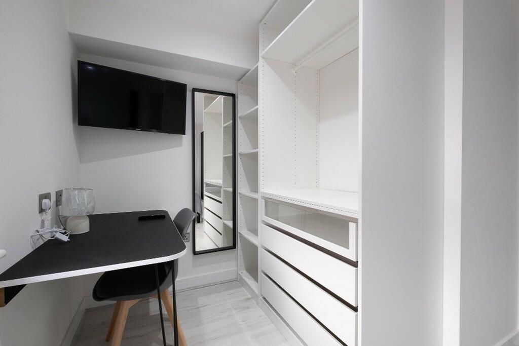 This stylish single bedroom features a sleek de...