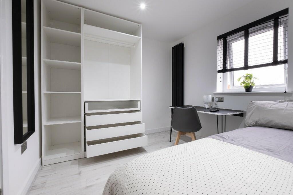 This inviting double bedroom features a spaciou...