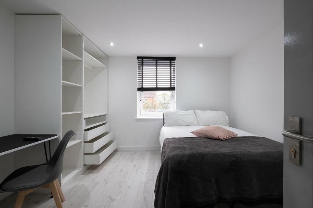 This stylish double bedroom features a cozy atm...