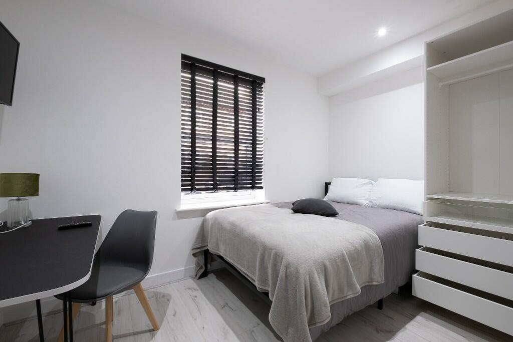 This inviting double bedroom features a comfort...