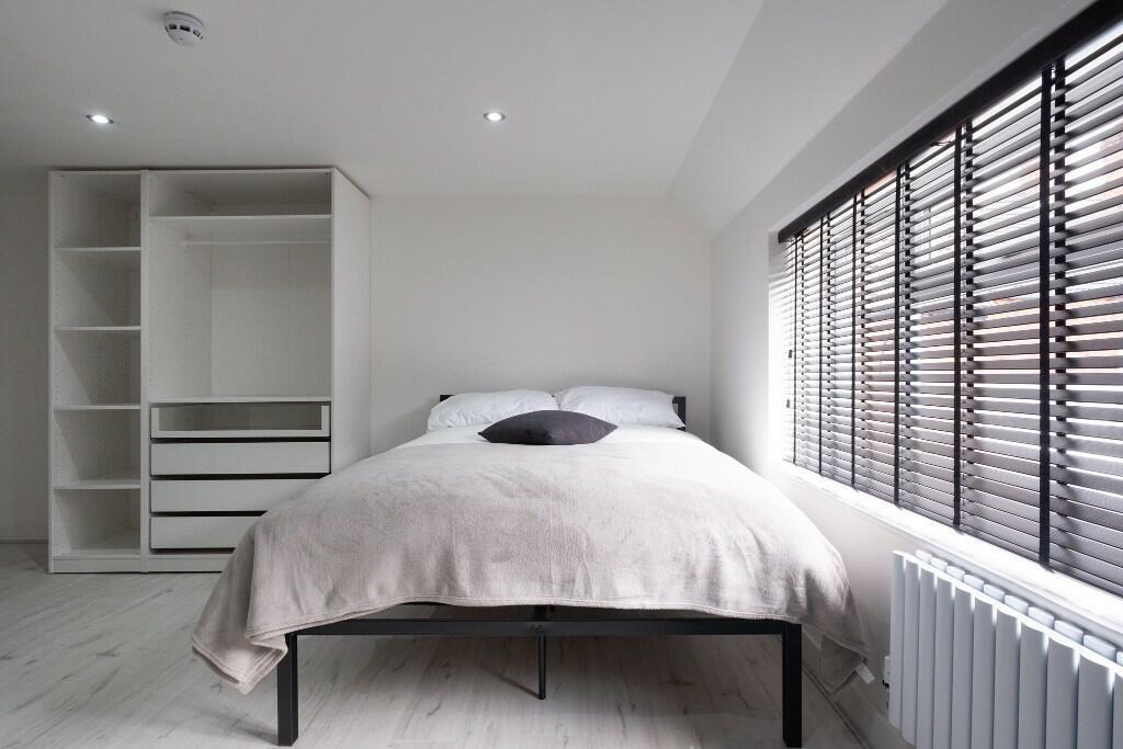 A bright and modern bedroom featuring a double ...