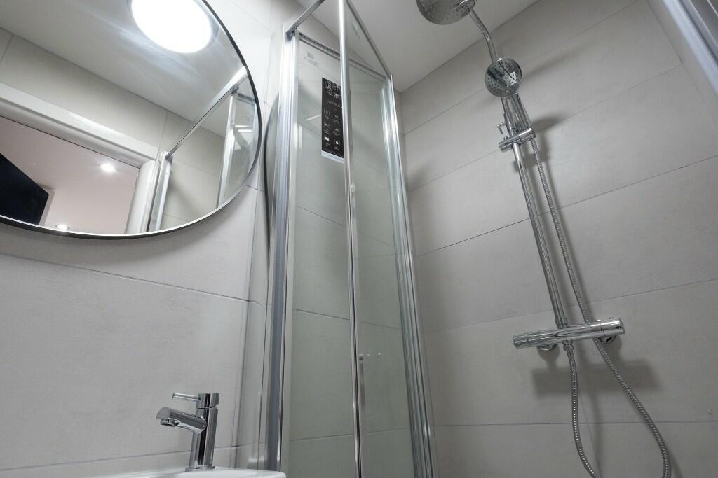 A modern bathroom featuring a shower enclosure ...