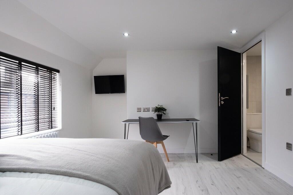 A bright, spacious master bedroom with a large ...