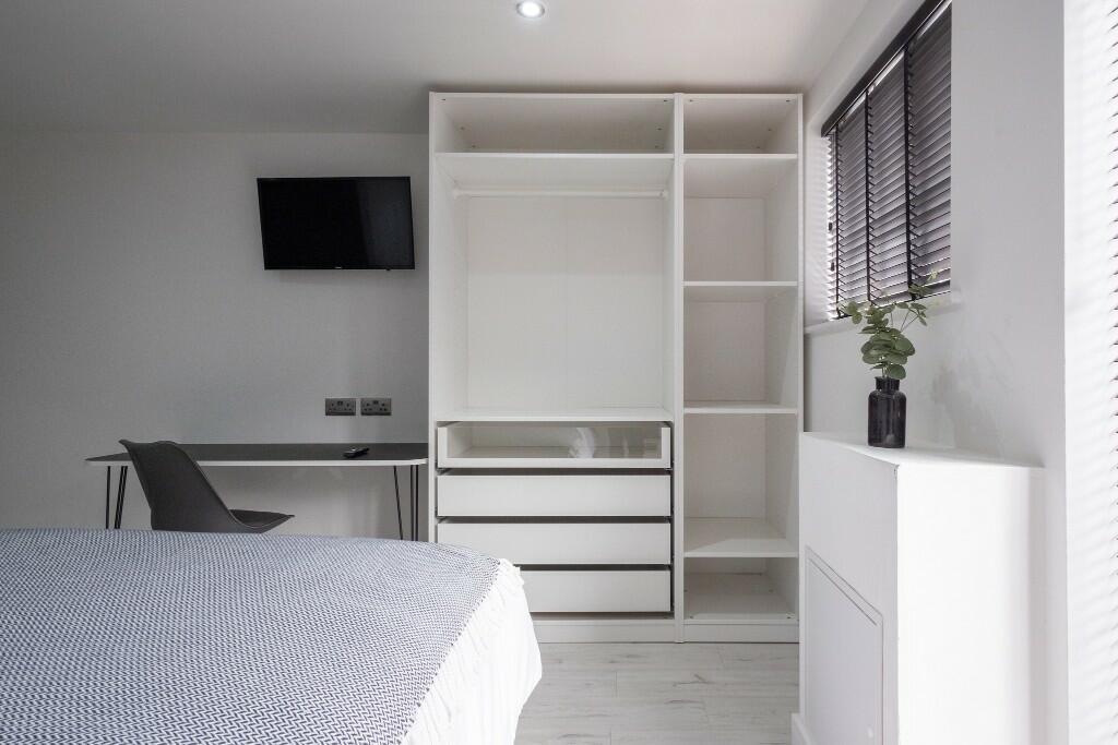 Bright, modern double bedroom with built-in war...