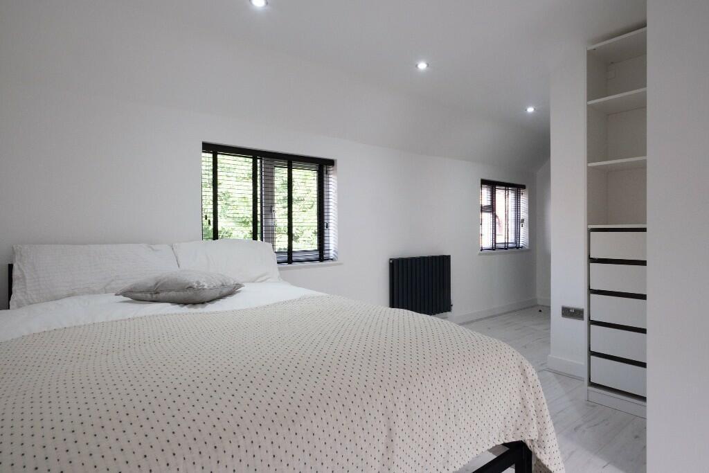 Bright and spacious master bedroom with a comfo...