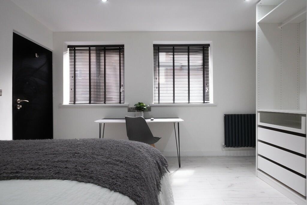 A modern, bright living room with large windows...