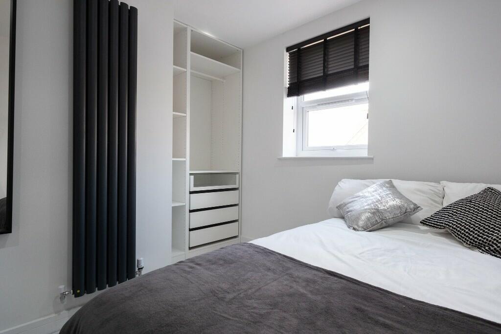 A modern and tidy bedroom featuring a double be...