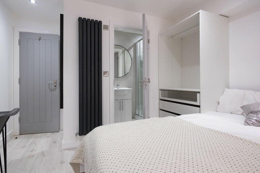 A spacious and bright master bedroom featuring ...