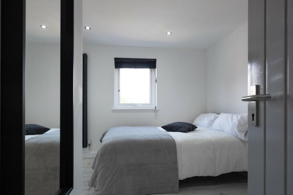A bright and tidy master bedroom featuring a co...