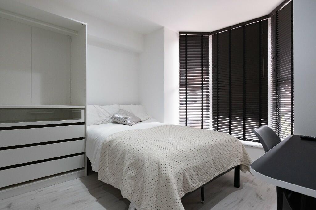 A bright and modern bedroom featuring a spaciou...