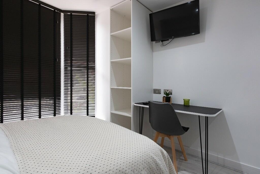 A bright and modern bedroom featuring a comfort...