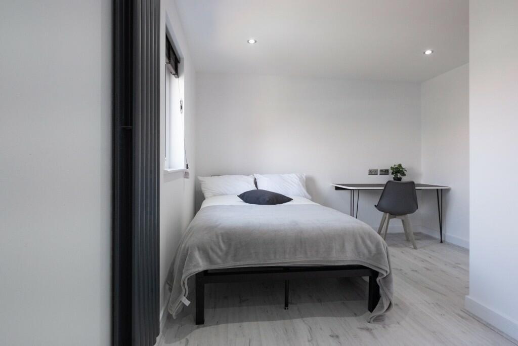A bright and modern bedroom featuring a neatly ...