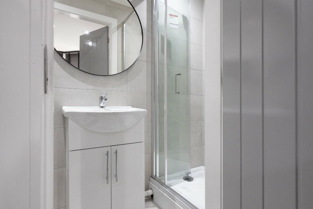 A modern, clean bathroom featuring a large show...
