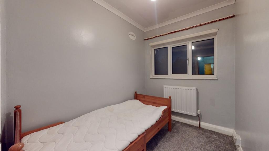 Cozy single bedroom with a simple wooden bed, n...