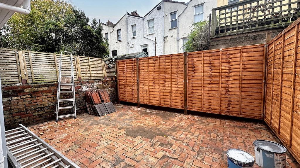 Private paved rear garden with enclosed wooden ...