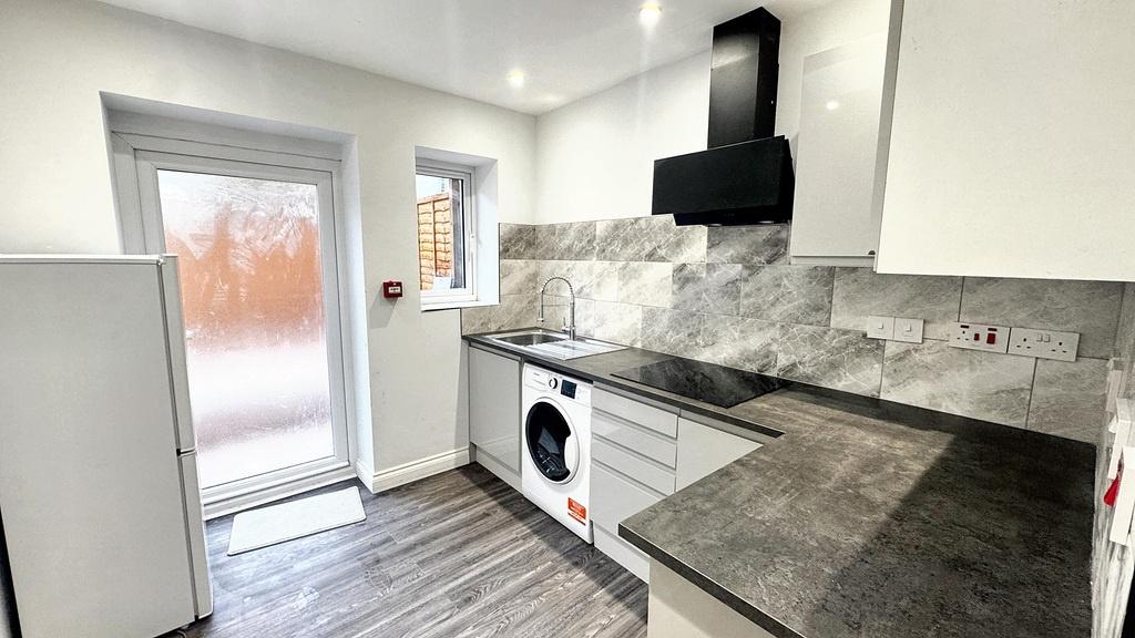 Bright modern kitchen with sleek grey worktops,...