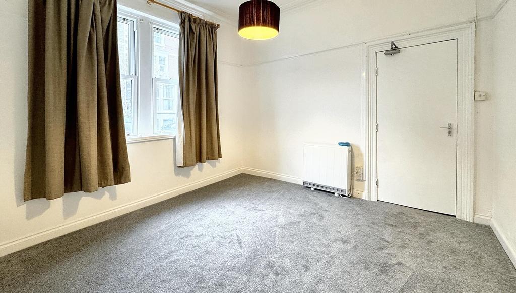 Bright, neutrally decorated bedroom with a larg...