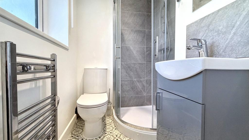 Modern bathroom with a curved glass shower encl...