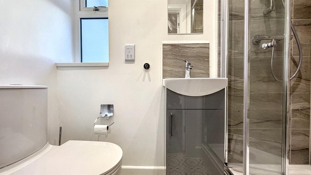 Modern bathroom with a white toilet, compact va...