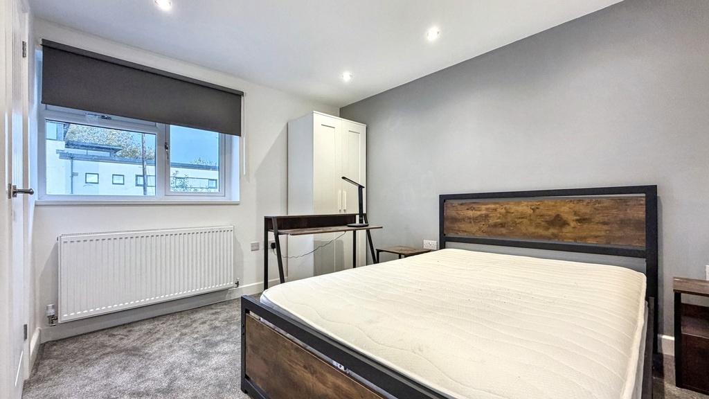 Bright, modern bedroom with a large window, neu...