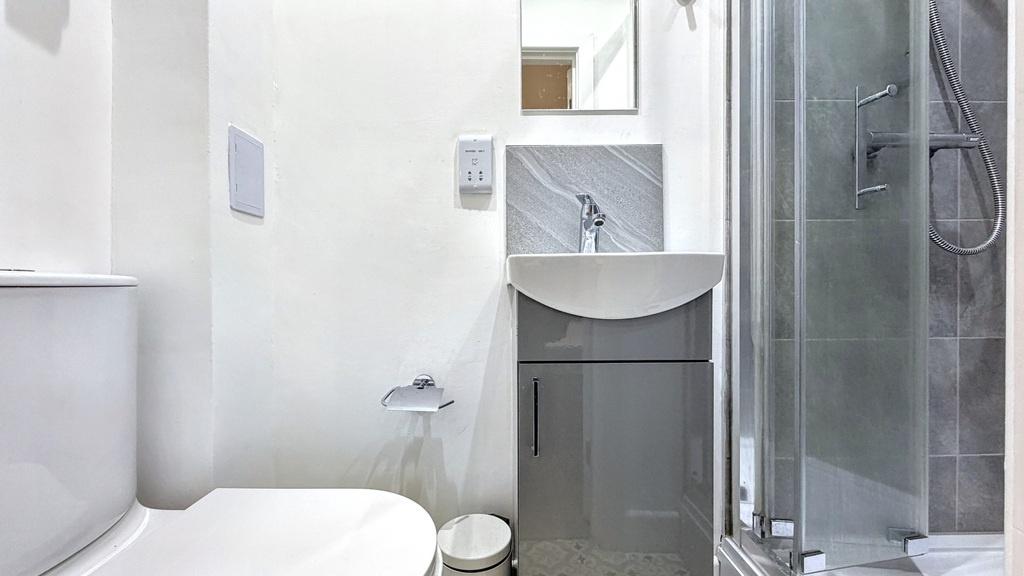 Bright, modern bathroom with a sleek corner sho...