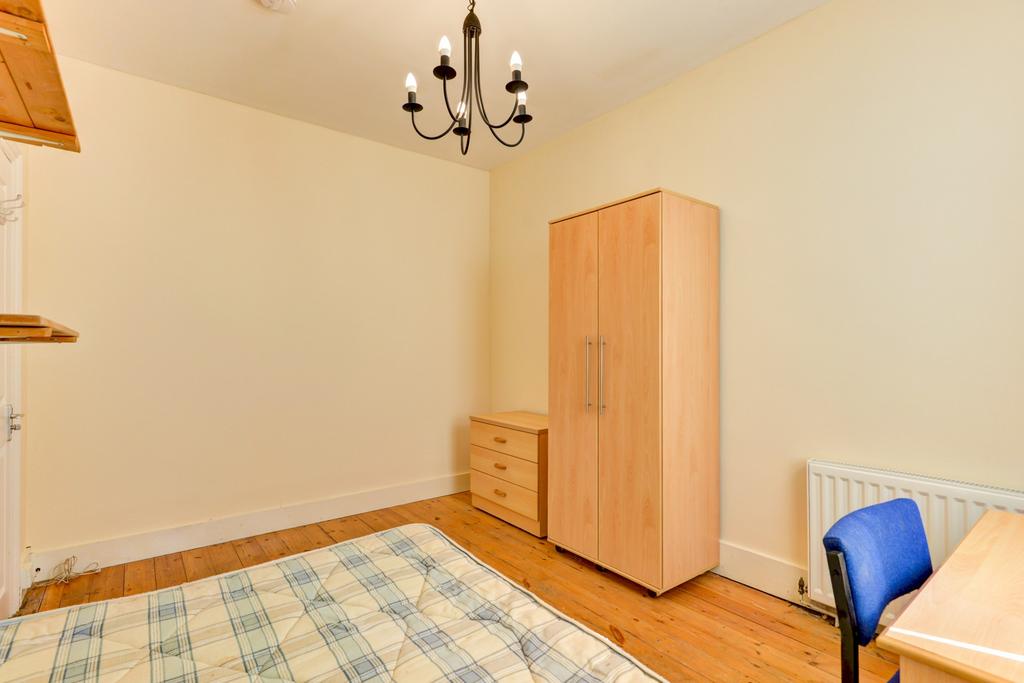 A well-maintained bedroom featuring a simple wa...
