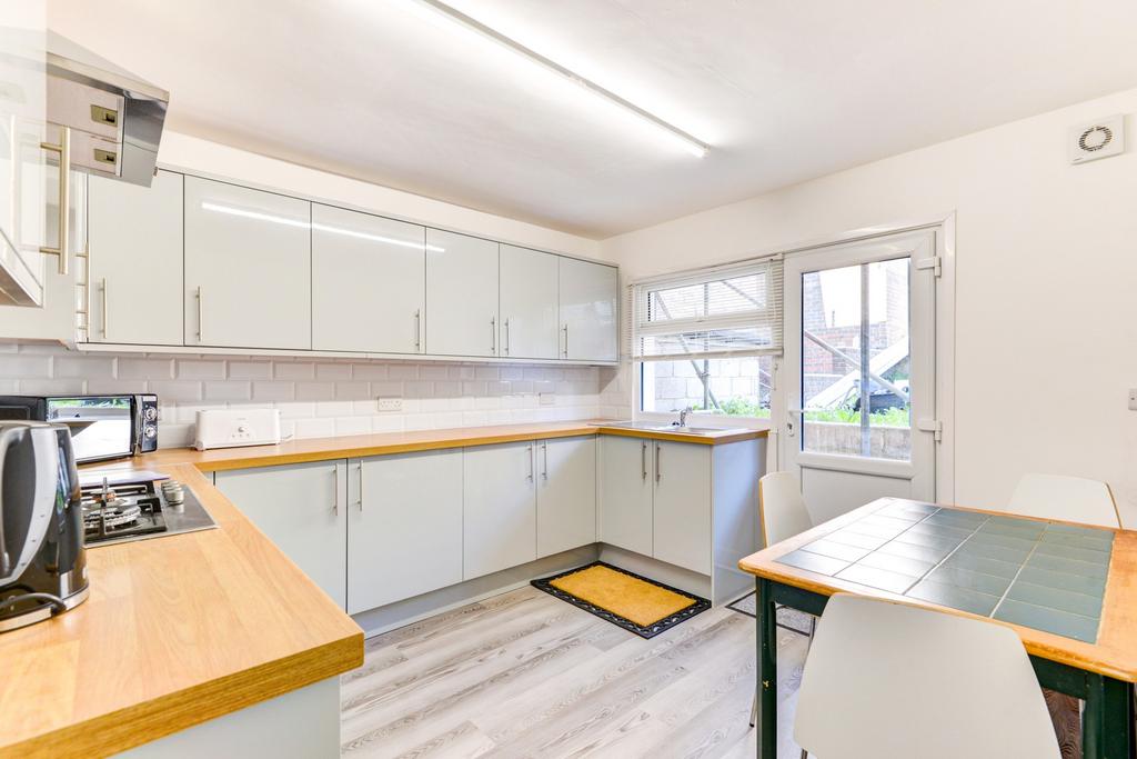 A bright and clean kitchen featuring modern whi...