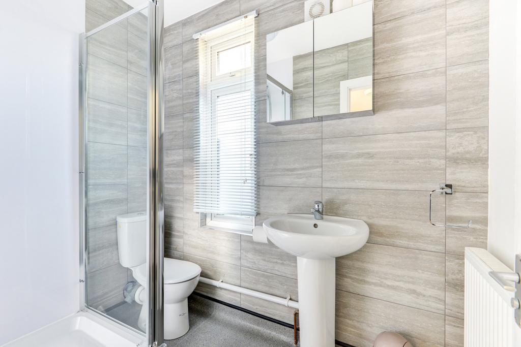 A modern, clean bathroom featuring a shower enc...
