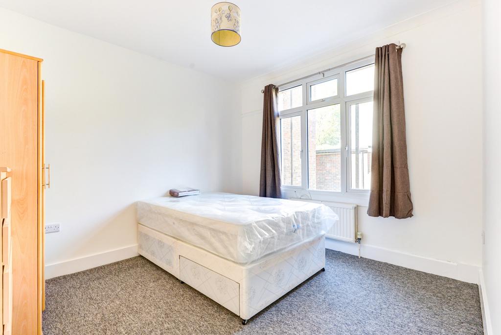 A bright, tidy single bedroom with a large wind...