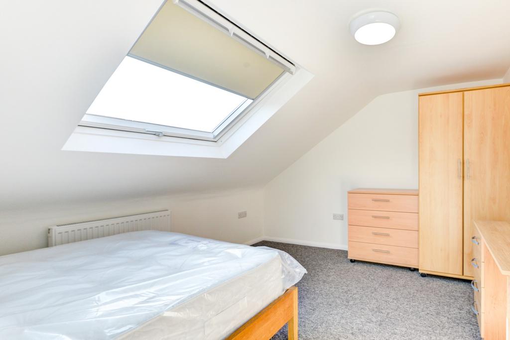 A bright and tidy bedroom with a large skylight...