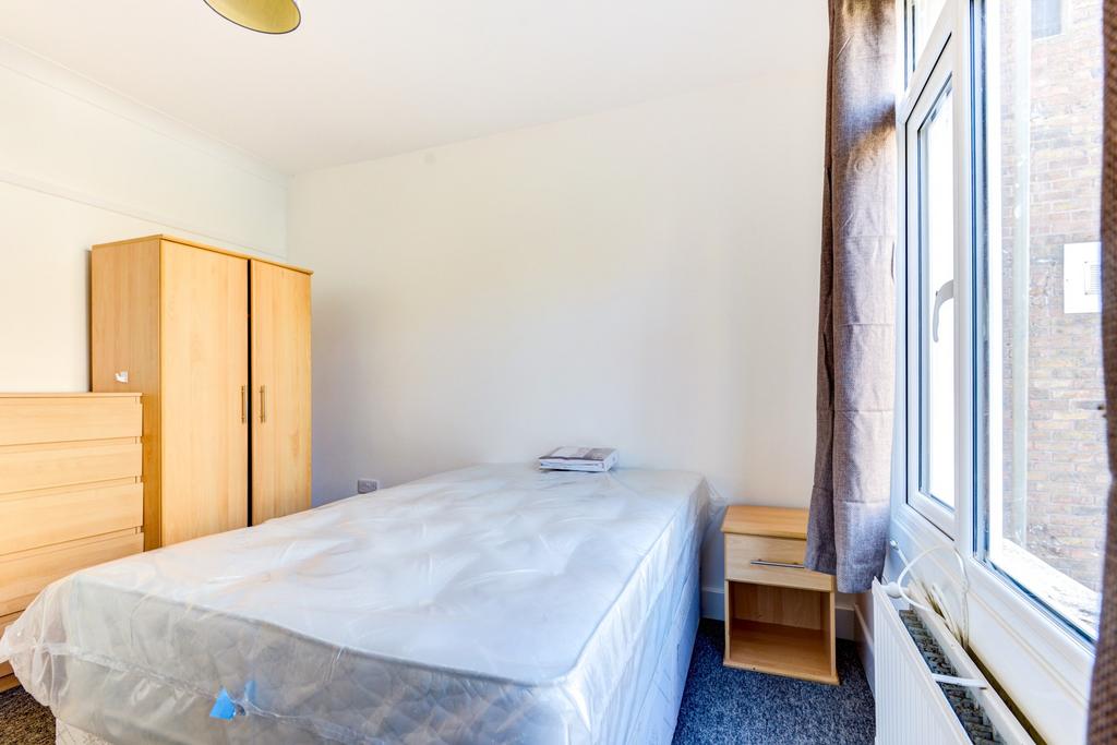 A bright and tidy single bedroom featuring a be...