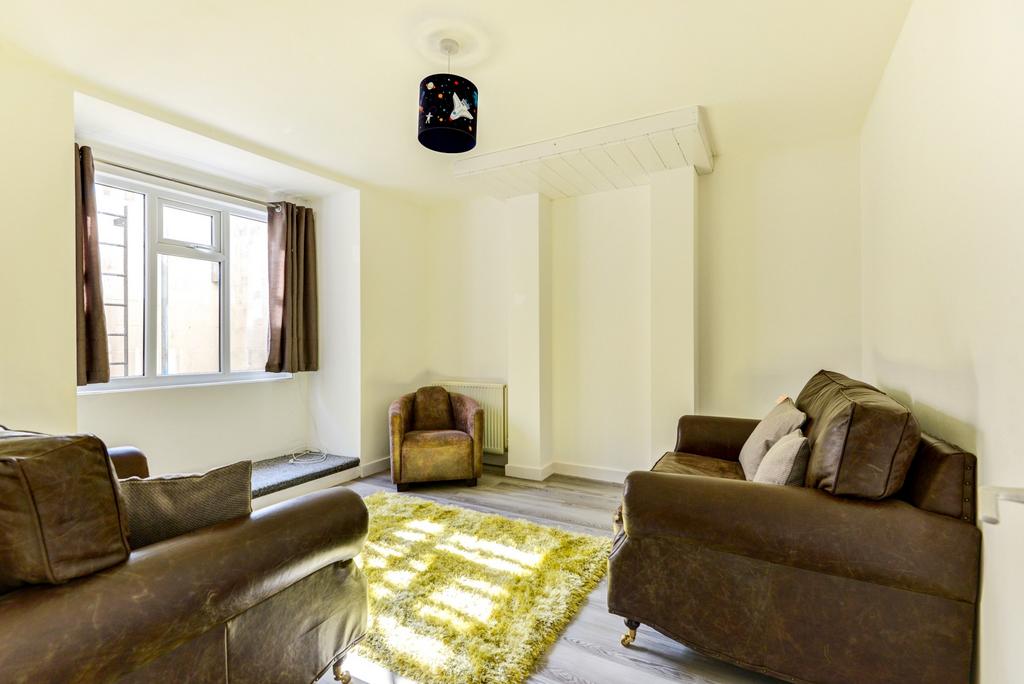 A well-lit, spacious living room featuring comf...