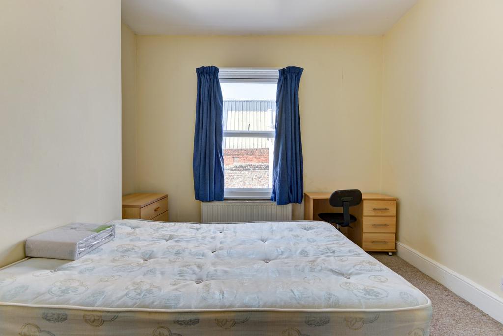 A spacious double bedroom featuring a large bed...