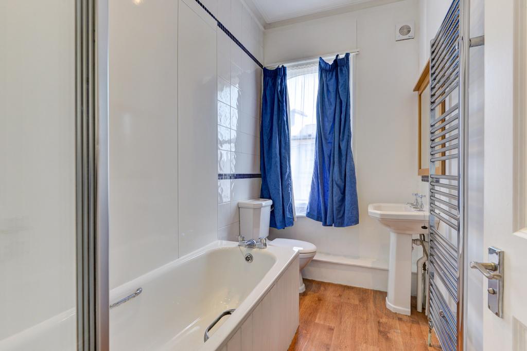 A well-maintained bathroom featuring a bathtub,...