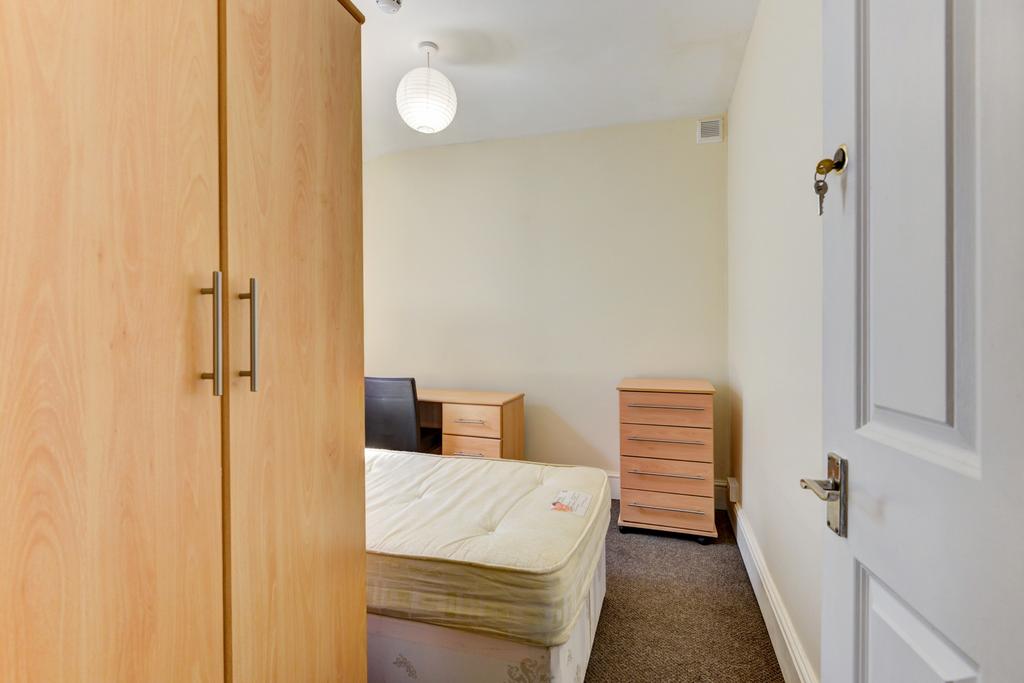 A well-maintained bedroom with a single bed, a ...