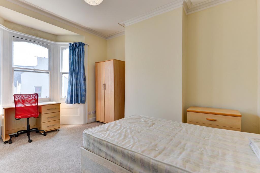 A cozy student bedroom featuring a single bed, ...