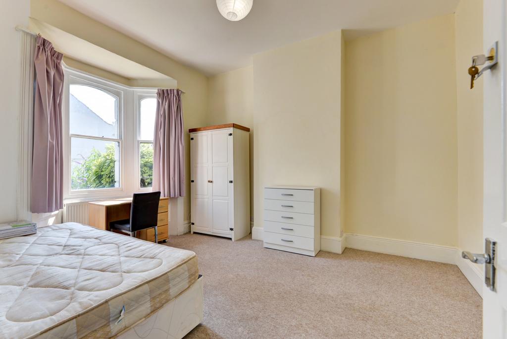 A well-lit bedroom featuring a large window wit...