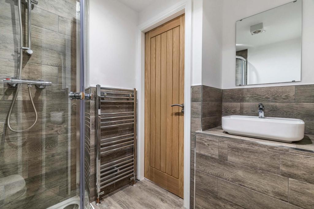Modern en-suite bathroom with a frameless glass...
