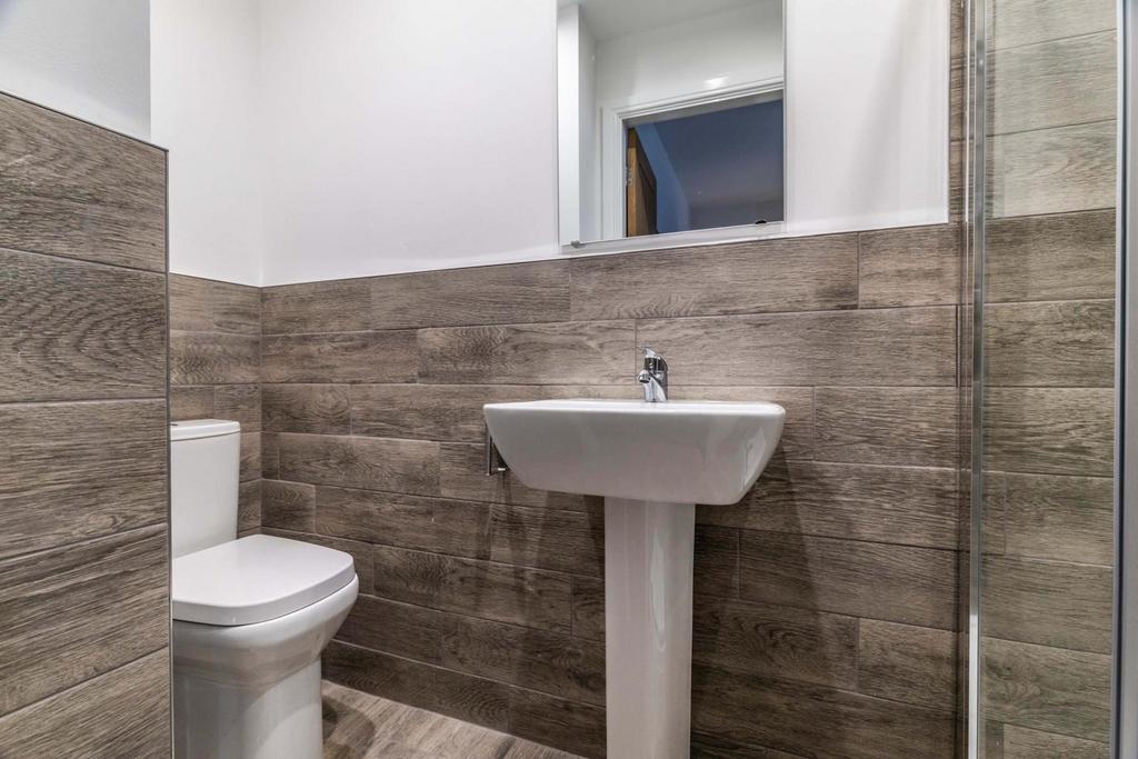 Modern bathroom with wood-effect wall tiles, wh...