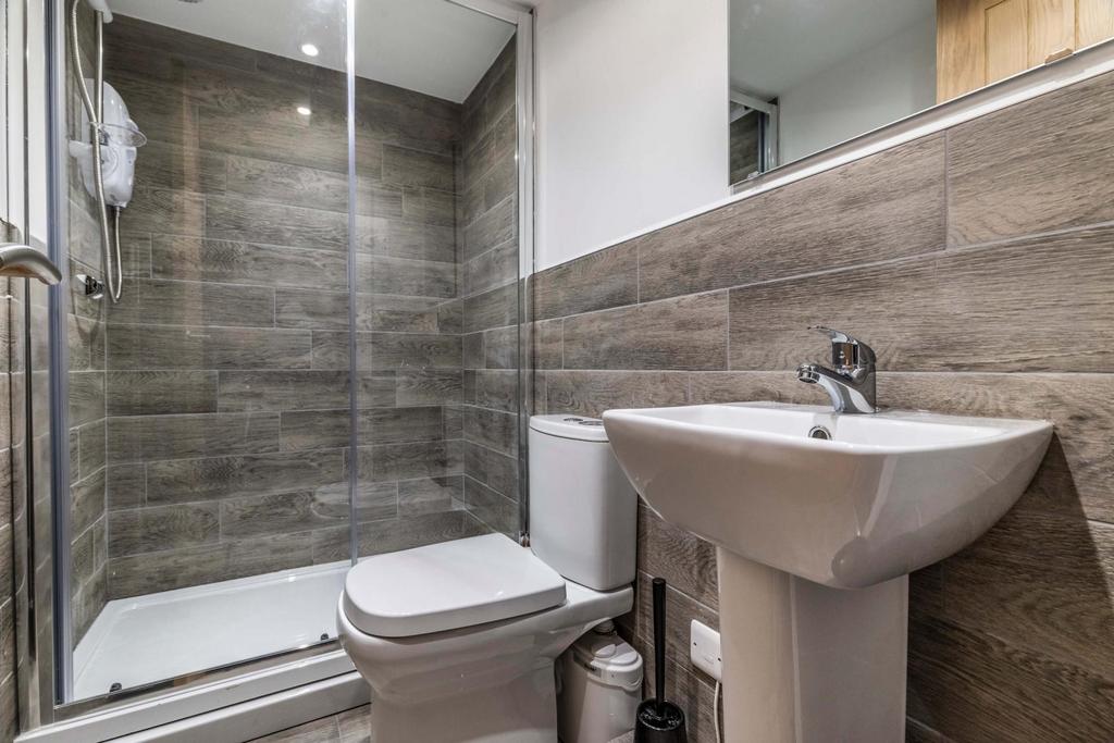Modern ensuite bathroom featuring a walk-in gla...