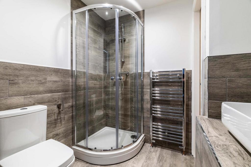 Modern bathroom with a curved glass shower encl...