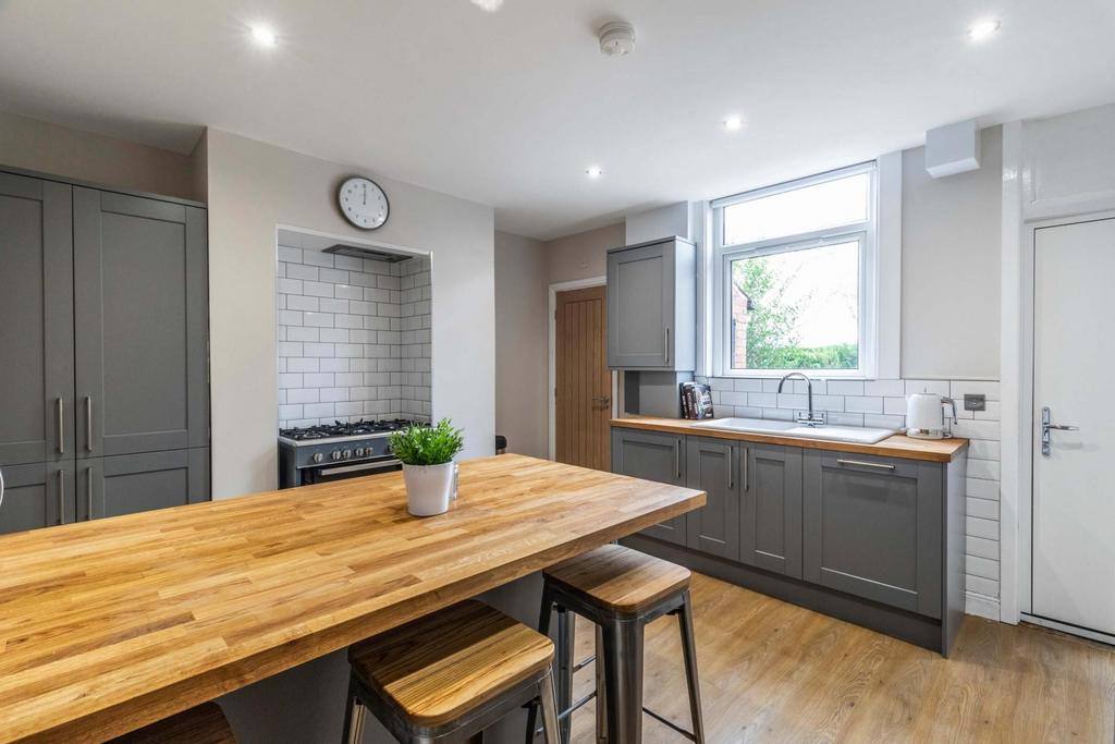 Bright, modern kitchen with a large wooden isla...