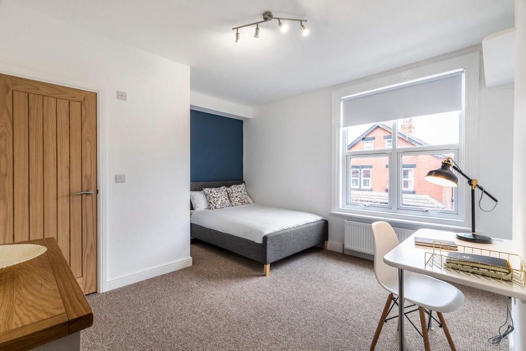 Bright, neatly furnished bedroom with a double ...