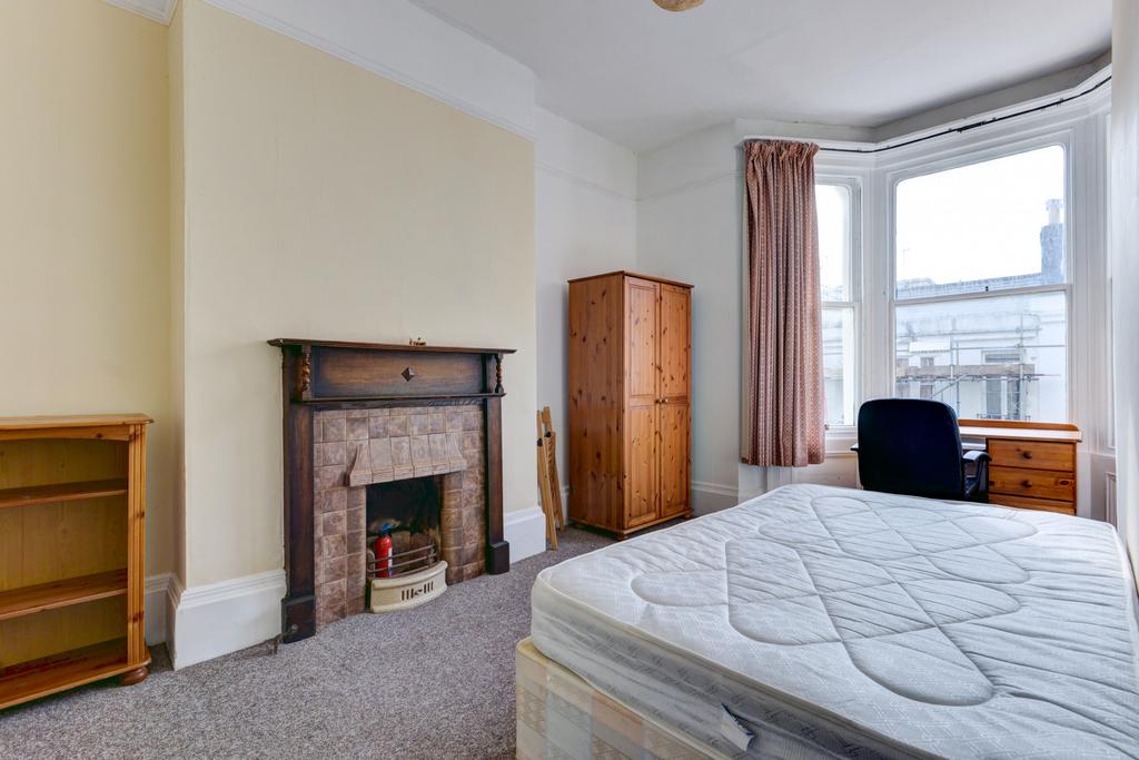 A well-lit spacious master bedroom featuring a ...