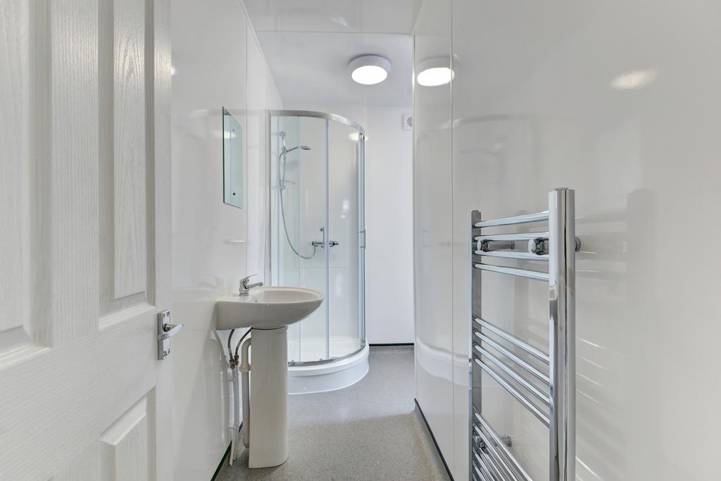 A modern, clean bathroom featuring a shower cab...