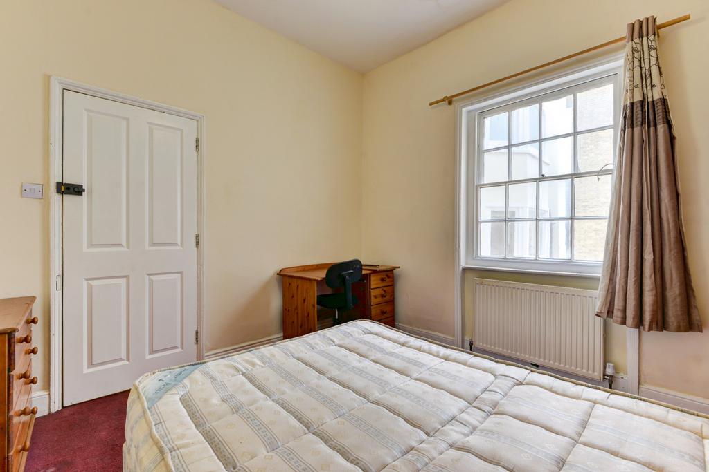 A bright and inviting bedroom featuring a comfo...