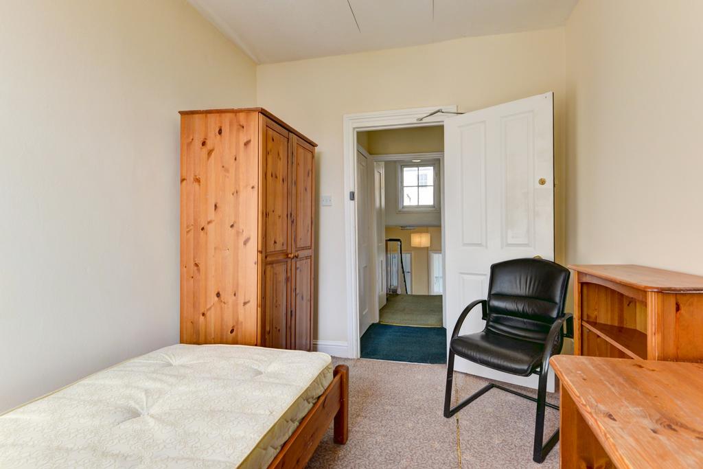 A bright and simple single bedroom featuring a ...